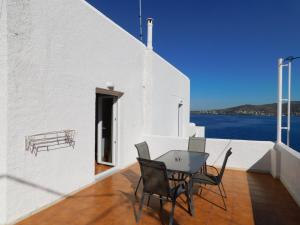 a table and chairs on a balcony with a view of the water at Perdika Mare Guesthouse in Perdika