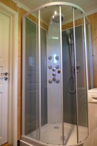 una ducha con mampara de cristal en un baño en Koselig Hytte i Nykvåg, en Nykvåg 37 fotos más