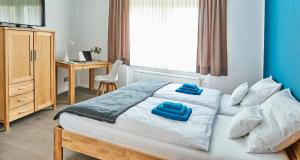 um quarto com uma cama com duas almofadas azuis em SCHLAFGUT! HOTEL-WILL.ICH Garni em Willich