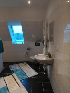 ein Bad mit einem Waschbecken, einem Spiegel und einem Fenster in der Unterkunft Ferie Apartment Skovby Fyn in Bogense