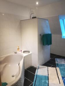 ein Badezimmer mit einer weißen Badewanne und einem grünen Handtuch in der Unterkunft Ferie Apartment Skovby Fyn in Bogense
