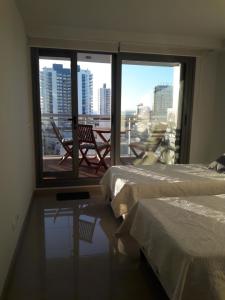 a room with two beds and a window with a view at Departamento en Punta del Este in Punta del Este +11 photos