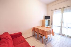 een woonkamer met een tafel en een rode bank bij Agenzia Vear Villa Marina in Lido delle Nazioni