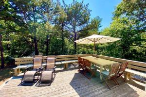 a table and chairs with an umbrella on a deck at Martha's Vineyard Vacation Home in Edgartown