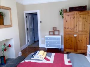 a room with a bed and a dresser at Lavender Apartment in Leicester