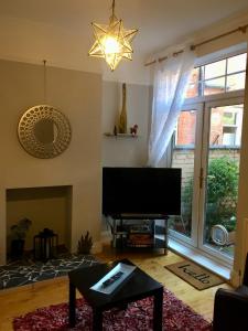 een woonkamer met een flatscreen-tv en een open haard bij Lavender Apartment in Leicester