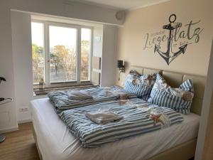 a bedroom with a large bed with a nautical sign on the wall at Loftappartement Sundowner mit fantastischem Meerblick in Prora in Binz