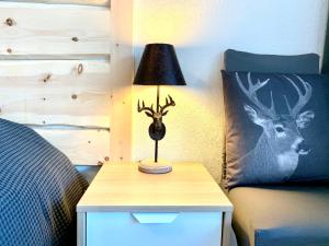 a lamp on a night stand next to a bed at Sehr zentral beim Jakobshorn, Bolgen, Skischule, Skivermietung, Bahnhof, Supermarkt, Restaurants, WIFI, Netflix und voll ausgestattet - Fewo Bolgen in Davos