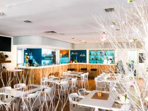 a restaurant with white tables and white chairs at Hotel Lis Mallorca in Palma de Mallorca