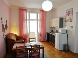 a living room with a table and a white refrigerator at Flamingo Apartments in Prague