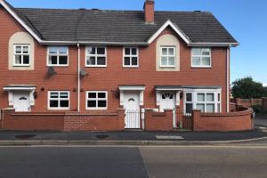 a red brick house with white doors and a fence at House number 4 Sleeps up to 5 with Smart TVs in every room in Wellington