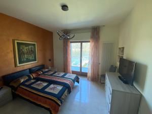 1 dormitorio con 1 cama y TV de pantalla plana en apartment Lac Brusimpiano, en Brusimpiano