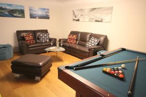 a living room with a pool table and couches at Appartements Julia in Zell am See
