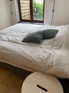 un letto con due cuscini e un tavolo e una finestra di Appartement cosy Spa a Spa