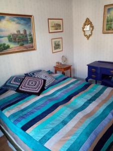a bedroom with a bed with a blue striped blanket at Foggy Island B&B in Kaskö