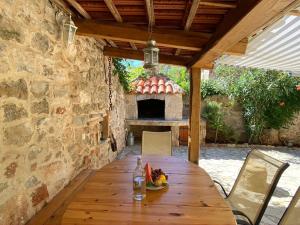 una mesa de madera frente a una pared de piedra con chimenea en Holiday Home Hauser en Vrbanj