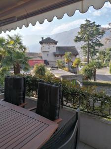 einen Balkon mit einem Tisch und Stühlen sowie Blick auf ein Gebäude in der Unterkunft Residenz degli Angioli in Ascona