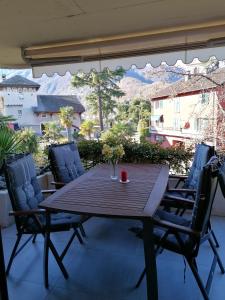 y balcón con mesa y sillas de madera. en Residenz degli Angioli, en Ascona