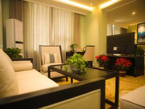 uma sala de estar com um sofá e uma mesa em GreenTree Alliance Texas Ningjin County Zhengyang Road Debai Plaza Hotel em Dezhou