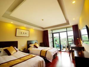 GreenTree Inn JiangSu SuZhou Science and Technology City Business Hotel في سوتشو: غرفة فندقية بسريرين وشرفة