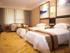 um quarto de hotel com três camas num quarto em GreenTree Alliance Texas Ningjin County Zhengyang Road Debai Plaza Hotel em Dezhou