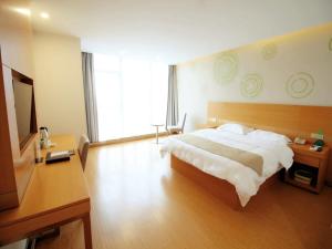 una camera da letto con un letto e una grande finestra di GreenTree Inn Suzhou South zhongshan Road Shangyi Bus Station Express Hotel a Suzhou