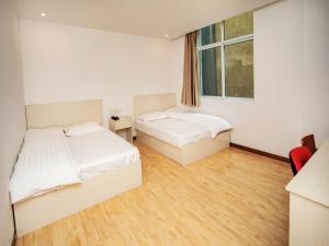 a bedroom with two beds and a window at Shell Huai'an Fishing Hook Town Hotel in Huai'an