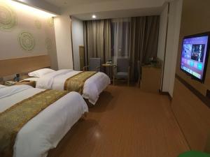 a hotel room with two beds and a flat screen tv at GreenTree Inn Shaoxing Binhai New City Dongsen Commercial Square Hotel in Shaoxing