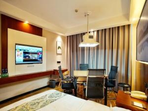 ein Hotelzimmer mit einem Bett, einem Tisch und Stühlen in der Unterkunft GreenTree Alliance Changzhou Jintan District Dongmen Street Hotel Hotel in Changzhou