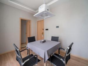 ein Esszimmer mit einem Tisch und vier Stühlen in der Unterkunft GreenTree Inn Jiangsu Wuxi Taihu Avenue Tongyang Road Express Hotel in Wuxi + 61 Fotos