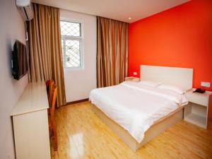 a bedroom with a white bed and a red wall at Shell Huai'an Fishing Hook Town Hotel in Huai'an