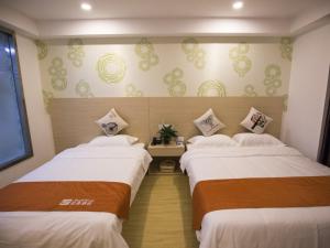 a hotel room with two beds in a room at Shell Huaian Xiamen Road Hotel in Huai'an