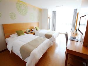 una camera d'albergo con due letti e una scrivania di GreenTree Inn Suzhou South zhongshan Road Shangyi Bus Station Express Hotel a Suzhou Altre 16 foto
