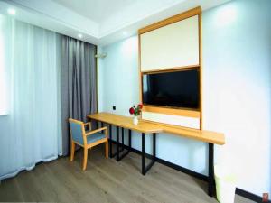 a room with a table and a window and a chair at GreenTree Inn Wuxi Jiangyin Changjing Town Selected Hotel in Wuxi