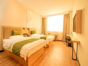 南京市にあるGreenTree Inn Nanjing Lukou Airportのベッド2台と窓が備わるホテルルームです。