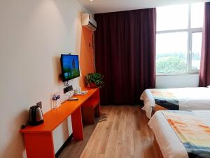 una camera d'albergo con due letti e una scrivania con televisore di Shell Tai'an Taishan District Xinhuacheng International Plaza Hotel a Tai'an
