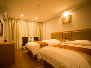um quarto de hotel com três camas e uma janela em GreenTree Inn JiangSu HuaiAn KangJian W) Road XiAn Road Business Hotel em Huai'an