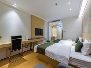 a hotel room with two beds and a desk and a television at GreenTree Eastern Xuzhou High Speed Railway Station West Exit Station Hotel in Xuzhou