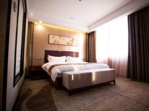 a bedroom with a large bed and a large window at GreenTree Eastern Bozhou Jingwan Wealth Centre Hotel in Bozhou