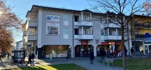 un edificio blanco con gente caminando delante de él en Appartementhotel Cura Bad Füssing, en Bad Füssing