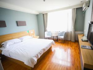 1 dormitorio con 1 cama blanca grande y TV en GreenTree Inn Jiangsu Yangzhou Jiangdu Development Zone Daqiao Town Express Hotel, en Jiangdu