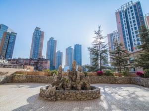 a statue in front of a city with tall buildings at GreenTree Eastern Kunming Baiyun Road Tongde Square Hotel in Kunming