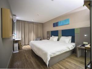 a hotel room with a large bed and a desk at GreenTree Inn Suzhou Kunshan Dongcheng Road International Exhibition Express Hotel in Penglang +20 photos