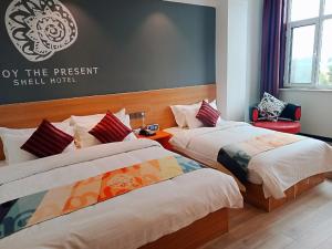 a hotel room with two beds and a sign on the wall at Shell Tai'an Taishan District Xinhuacheng International Plaza Hotel in Tai'an