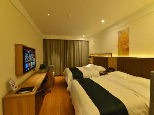 um quarto de hotel com duas camas e uma televisão de ecrã plano em GreenTree Inn Huludao Yuzhong County Central Road Smart Choice Hotel em Suizhong