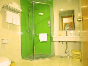 a green bathroom with a shower and a sink at GreenTree Inn Beijing Fangshan District Jingzhou Road Magezhuang Subway Station Express Hotel in Fangshan