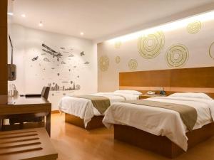 Una habitación de hotel con dos camas y un escritorio. en GreenTree Inn Changzhou Xixiasu Town Express Hotel, en Luoxi 22 fotos más