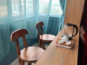 a wooden table with two chairs and a blender on it at GreenTree Inn ShanDong Jinan Railway Station Provincial Hospital Jinger Road Express Hotel in Jinan +38 photos