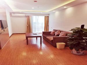 a living room with a couch and a table at GreenTree Inn Liaocheng Economic Development Zone Huitong Logistics Park Express Hotel in Liaocheng