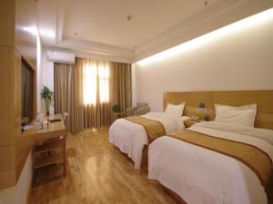 um quarto de hotel com duas camas e uma televisão em GreenTree Inn Shandong Laiwu Bus Station Express Hotel em Laiwu